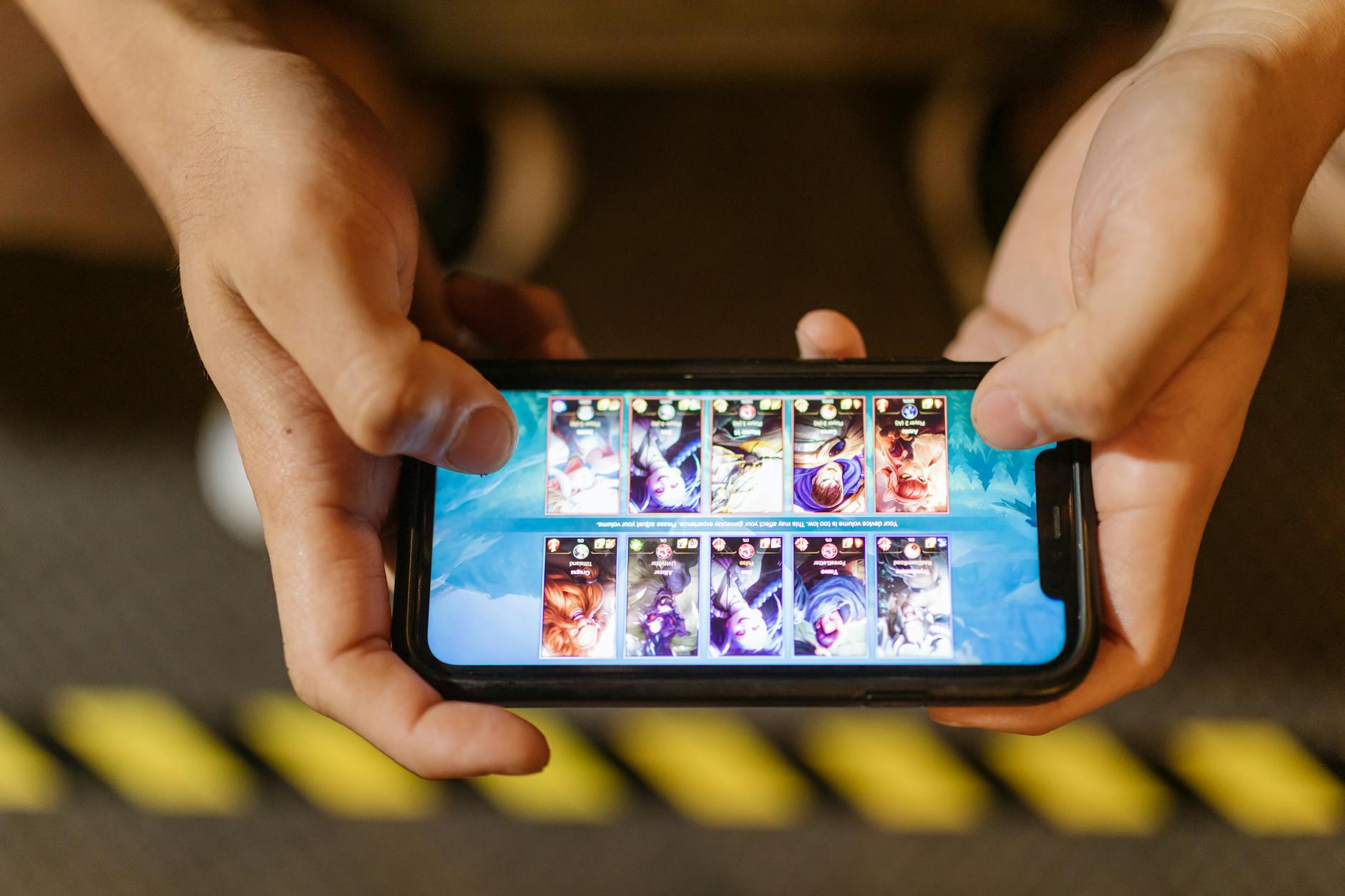 Người chơi dùng smartphone để trải nghiệm game giải trí trong không gian tối giản